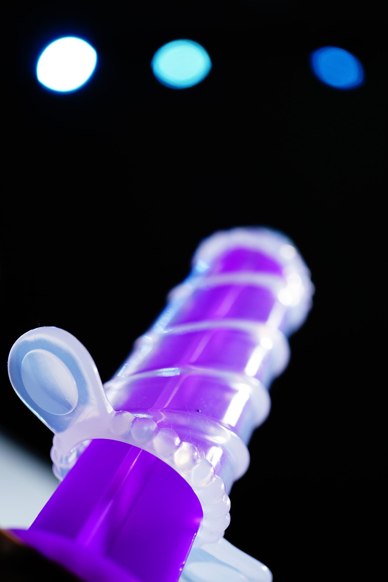 Purple and clear plastic part on black