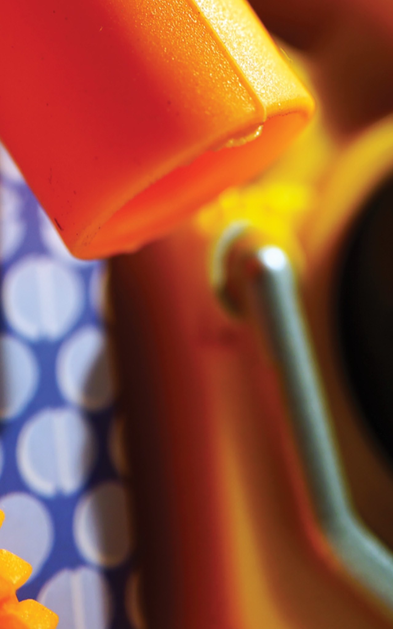 Orange plastic part on a polka-dot ground