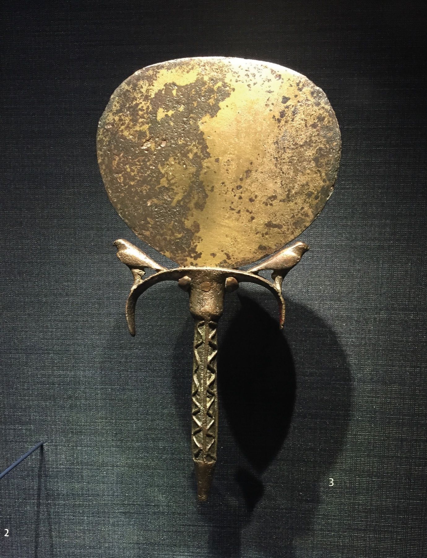 Antique hand mirror on a dark wall