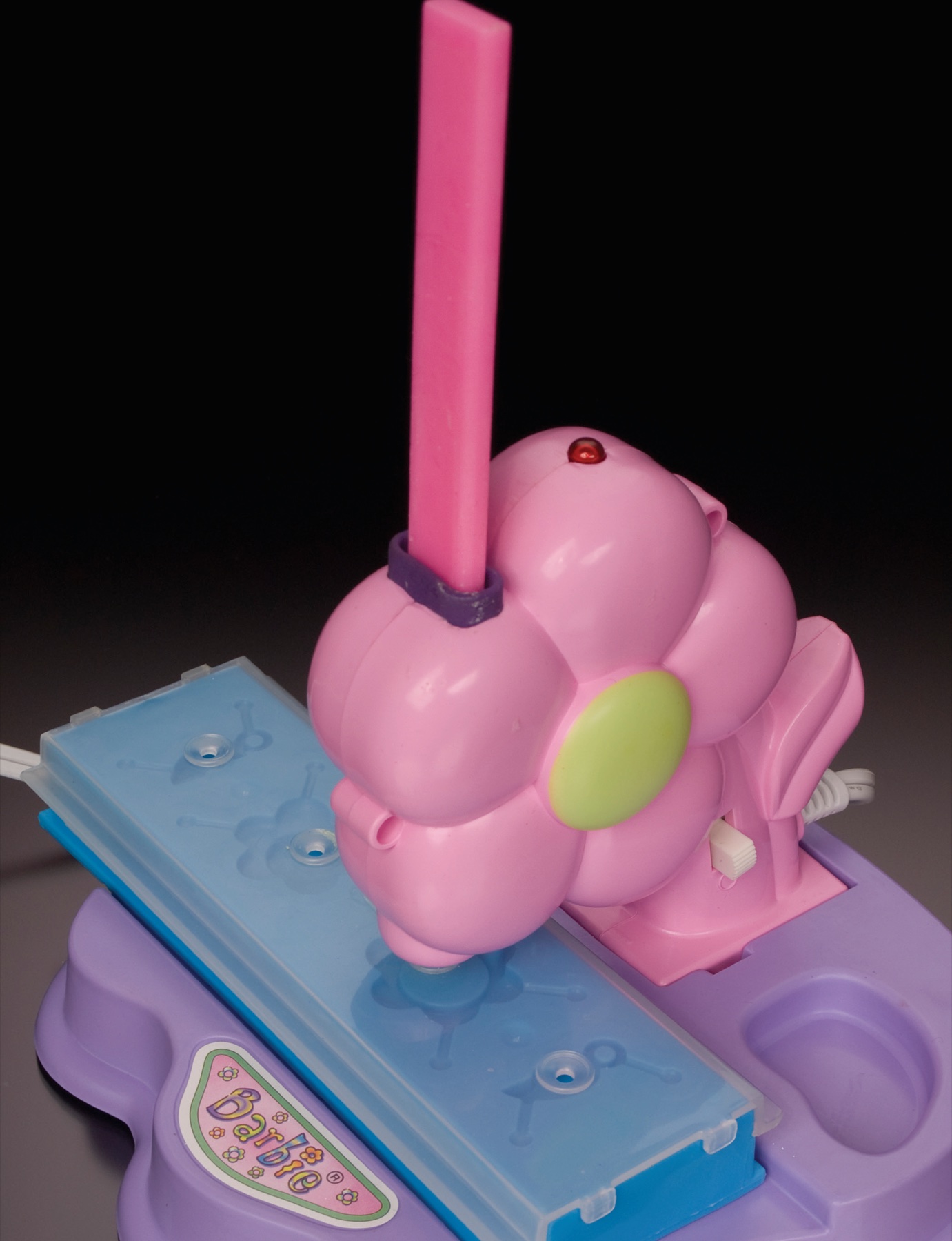 Pink plastic toy on a blue base